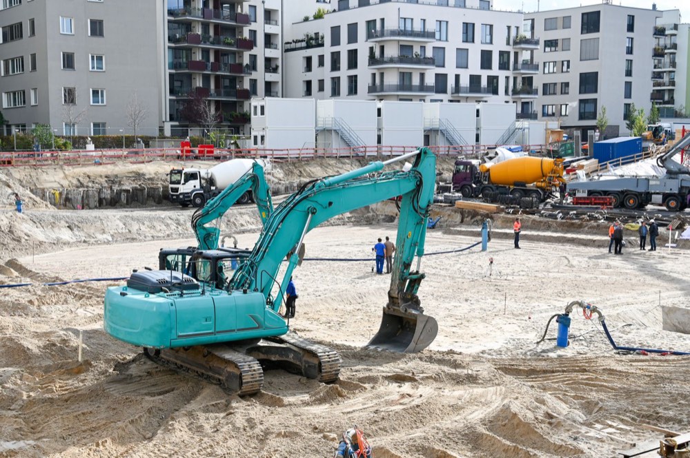 A retail building under construction, machinery and crew on site