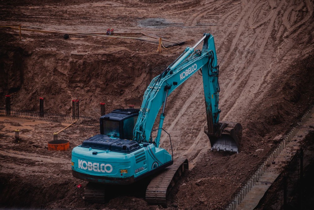 Excavator grading a retail pad site